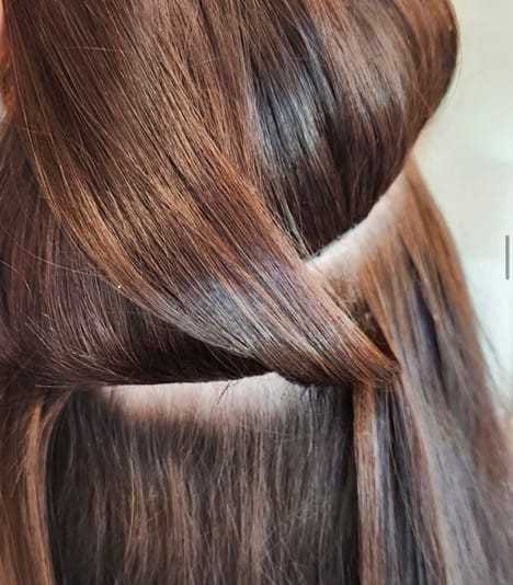 Close-up of brown hair styled in a sleek and shiny braid pattern.